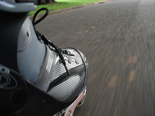 Image from the skate boots point of view going along a road.